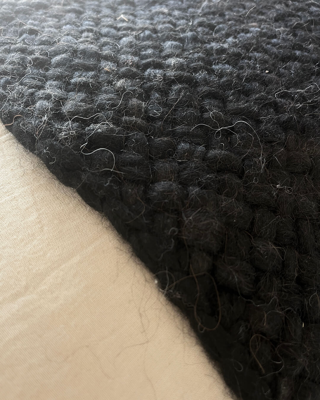 Close-up of the wool weave texture in Black, highlighting individual fibers.