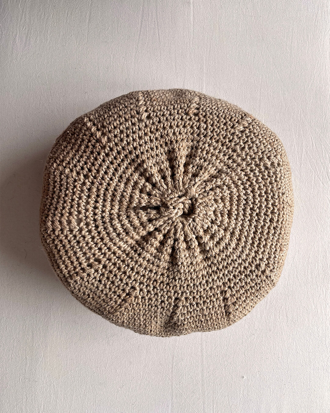 Round cushion in Beige-Sand and Natural White, shown from the back.