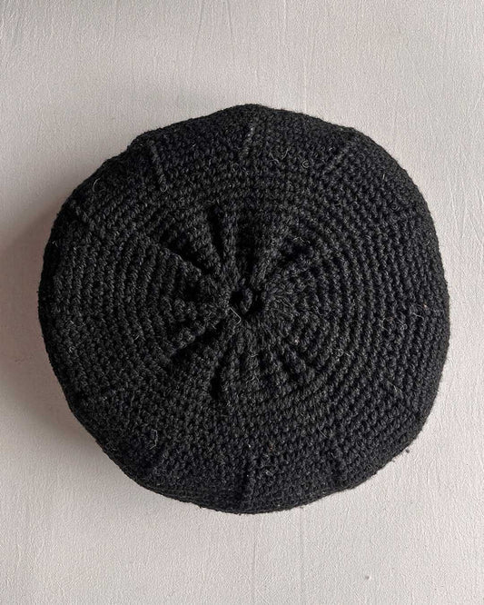 Round cushion in Black and Natural White, shown from the back.