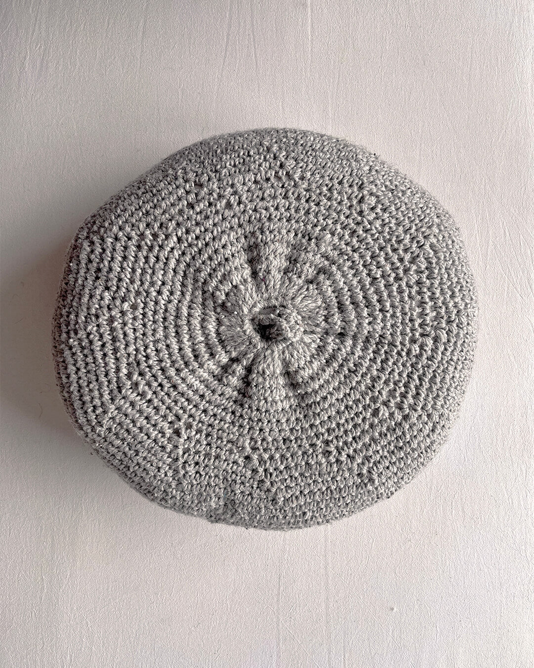 Round cushion in Gray and Natural White, shown from the back.
