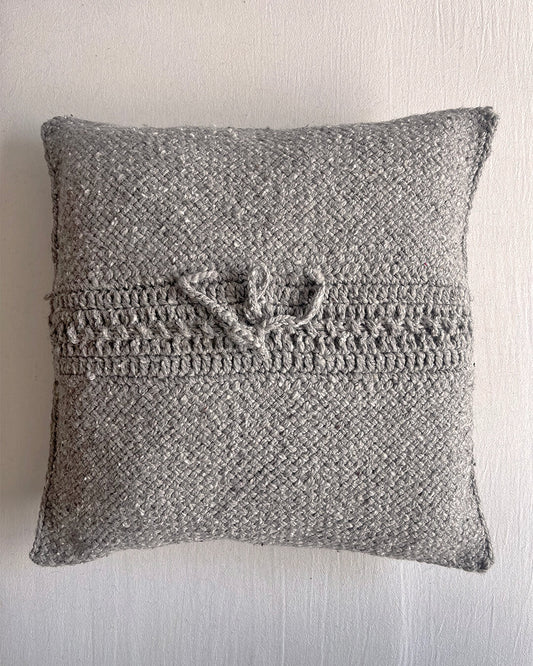 Gray-colored square wool cushion, shown from the back with woolen tie closure.