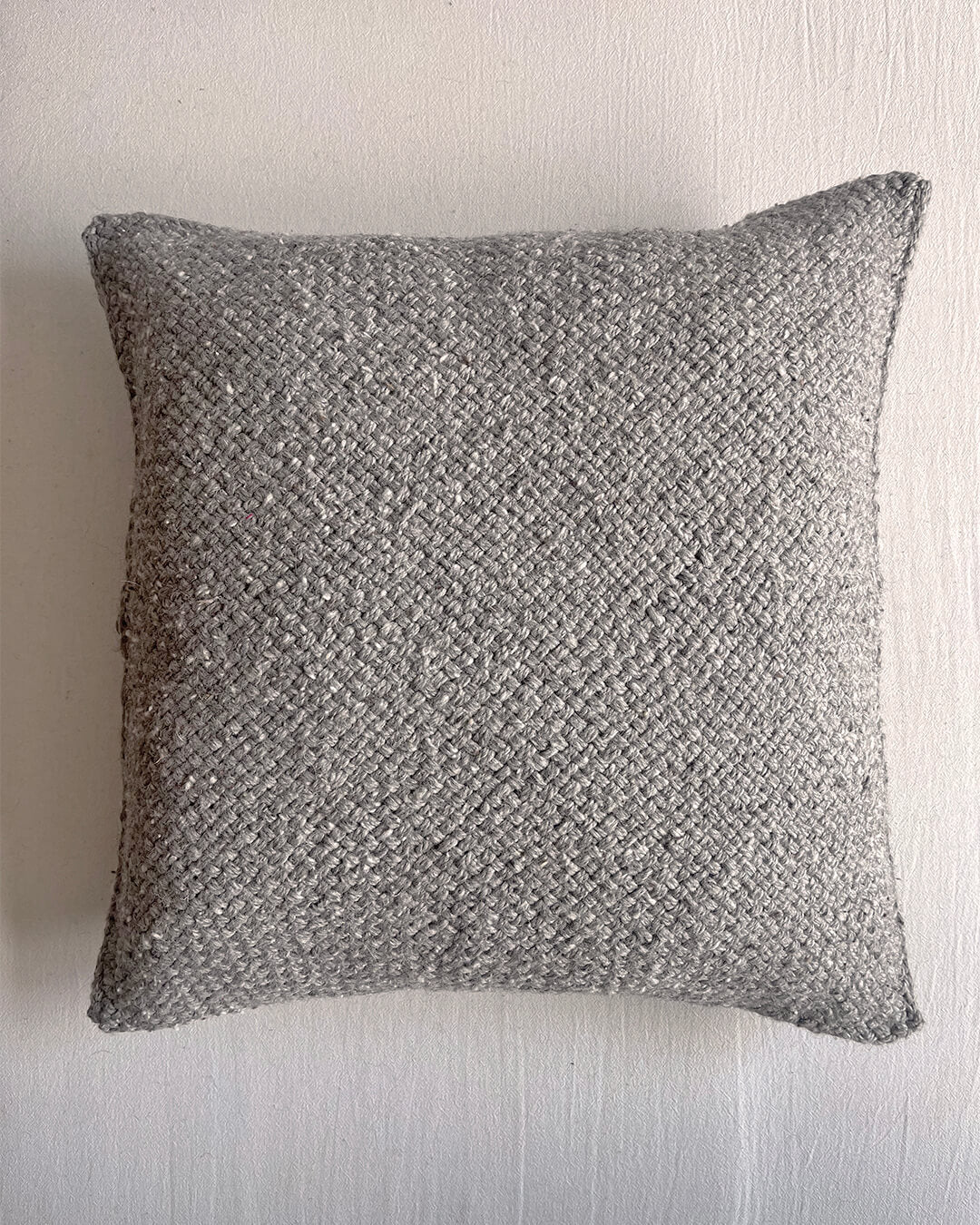 Gray-colored square wool cushion, shown from the front.