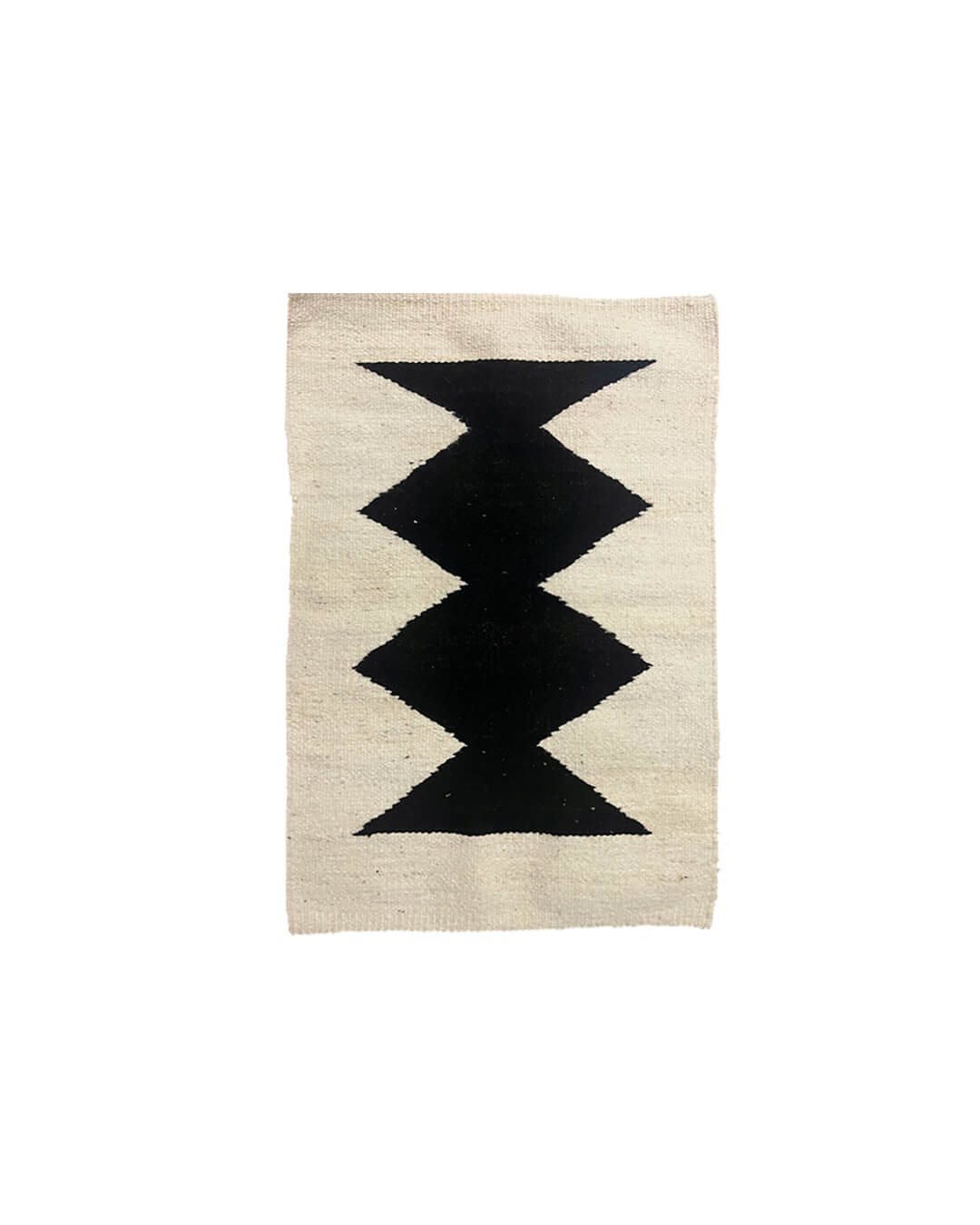 Handwoven CHACO Mini Rug featuring bold black geometric shapes on a natural wool background.