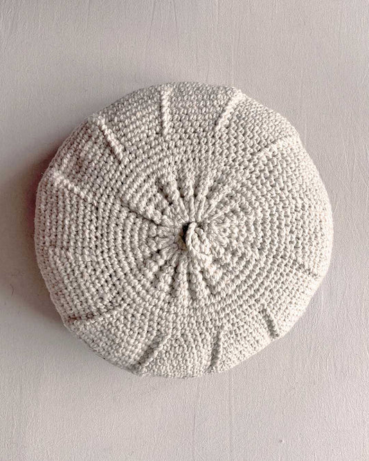 Round cushion in Natural White and Black, shown from the back.