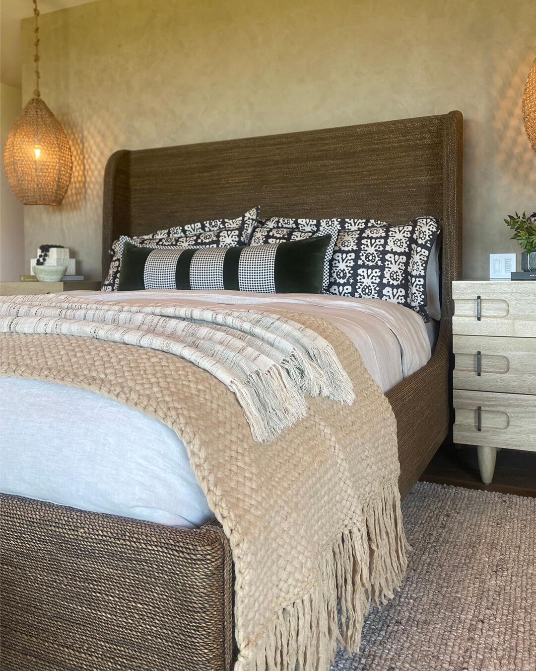 Beige-Sand wool throw styled at the foot of a bed in a natural-toned bedroom.