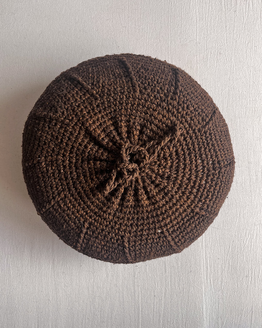 Chocolate Brown-colored round cushion without pom poms, shown from the back.