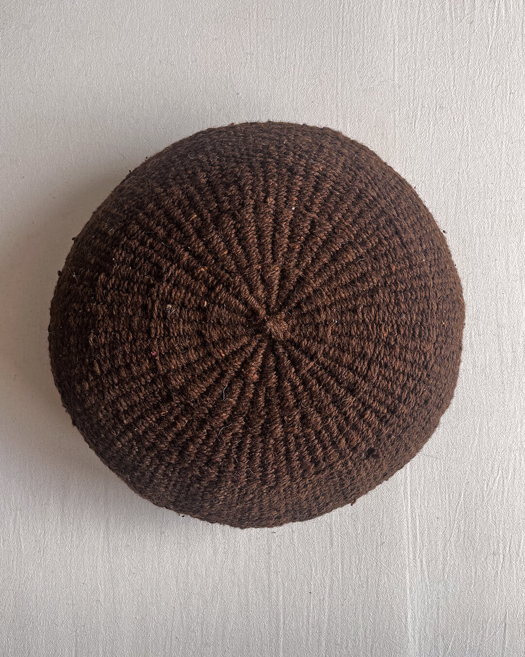Chocolate Brown-colored round cushion without pom poms, shown from the front.