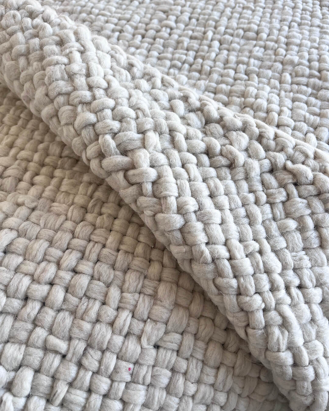 Natural White wool throw folded to reveal its thick, undyed weave.