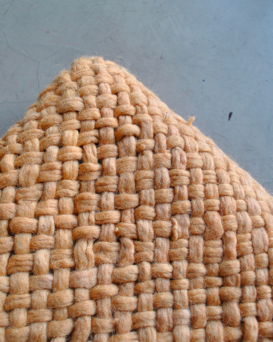 Close-up of the woven texture of the Camel wool throw.
