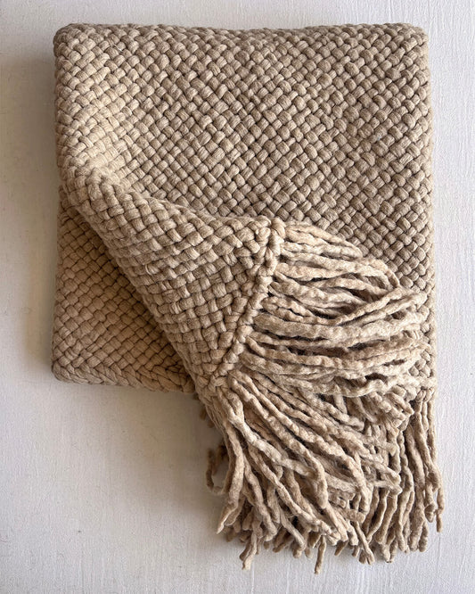 Beige-Sand wool throw partially unfolded to reveal weave and fringes.