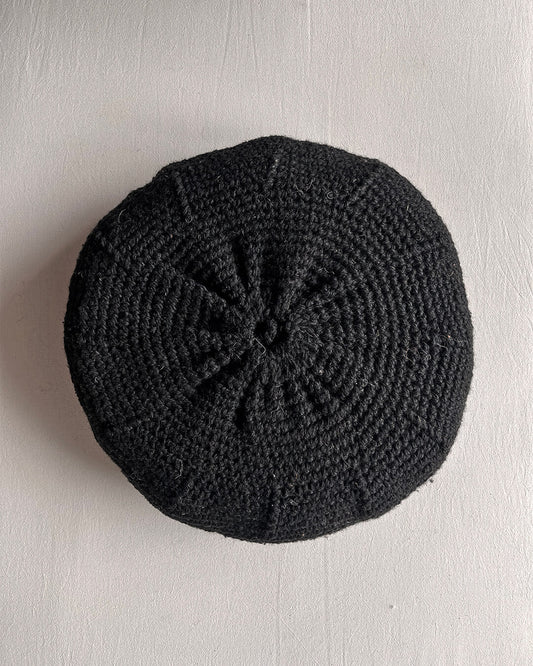 Round cushion in Black and Natural White, shown from the back.