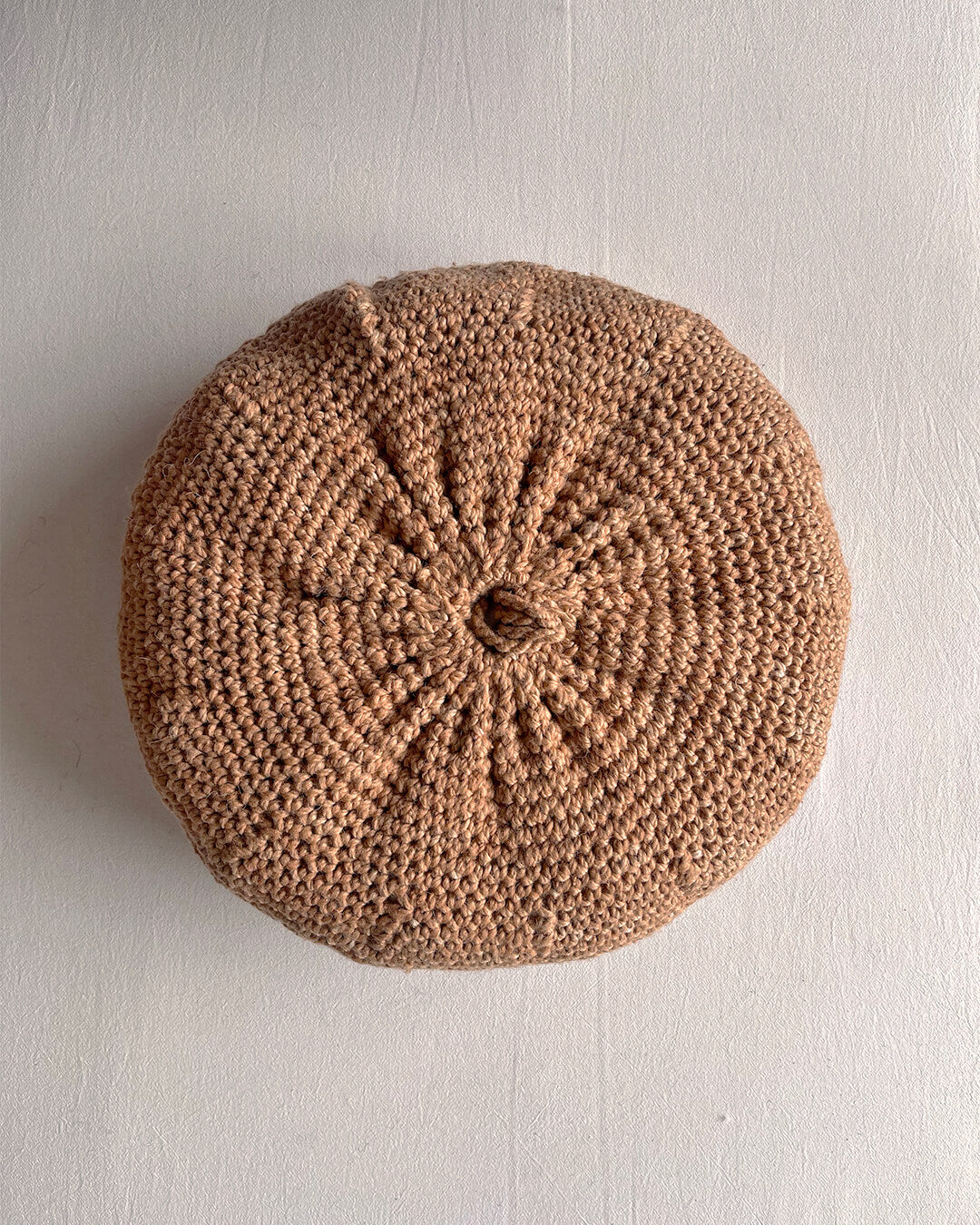 Round cushion in Camel and Natural White, shown from the back.