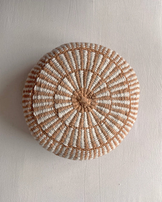 Round cushion in Camel and Natural White with comb-pattern design, shown from the front.