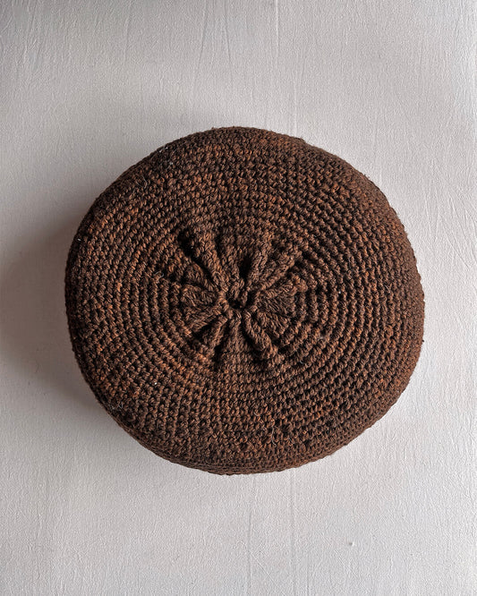 Round cushion in Chocolate Brown and Natural White, shown from the back.