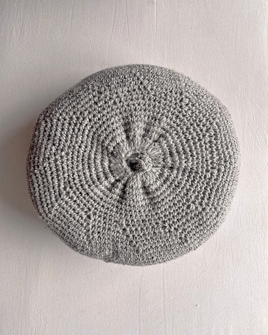 Round cushion in Gray and Natural White, shown from the back.