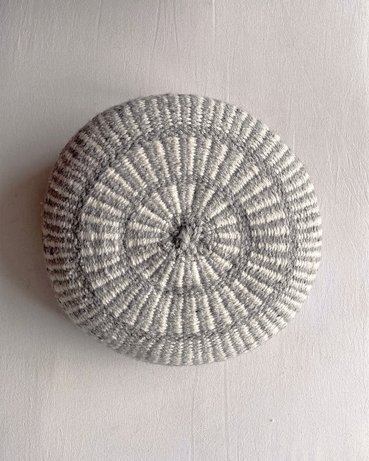 Round cushion in Gray and Natural White with comb-pattern design, shown from the front.
