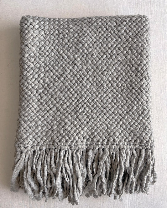 Folded Gray wool throw with visible texture and fringe on white background.