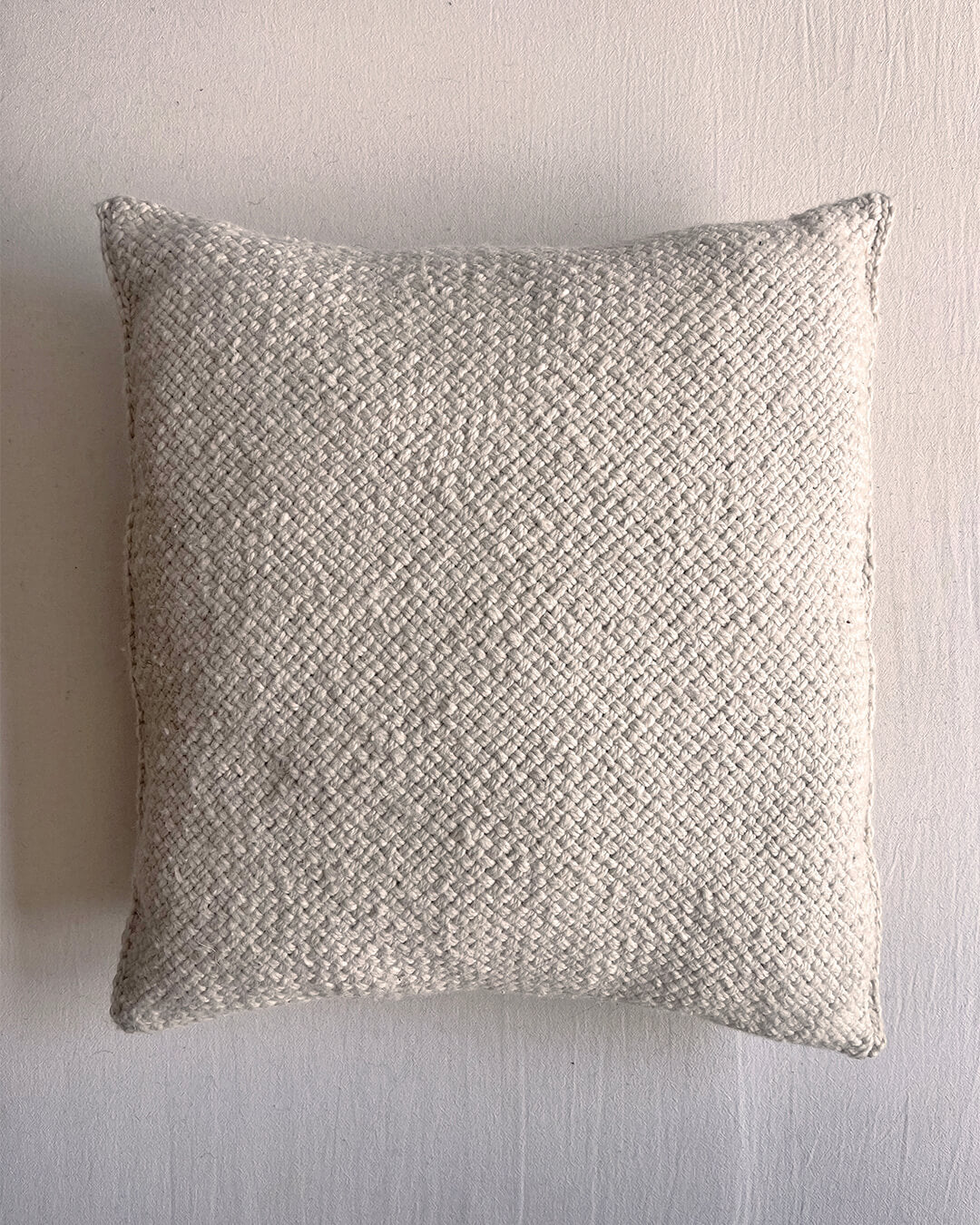 Natural White square wool cushion, shown from the front.
