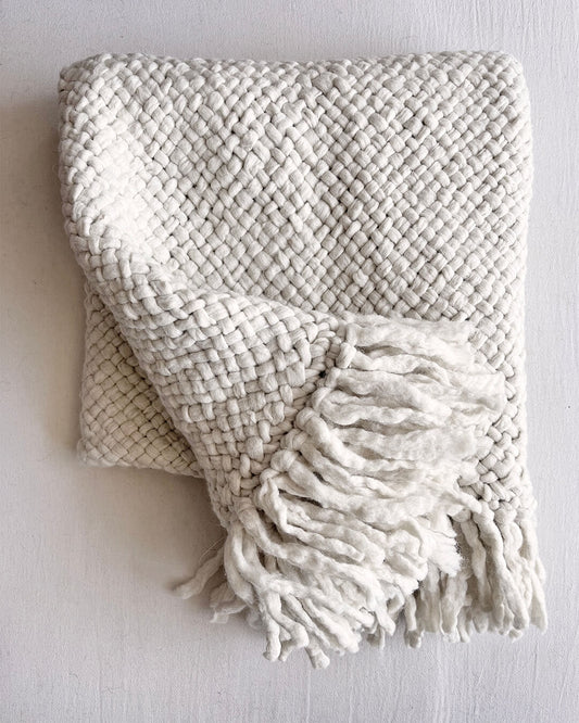 Natural White wool throw with front-facing fringe detail, folded neatly.