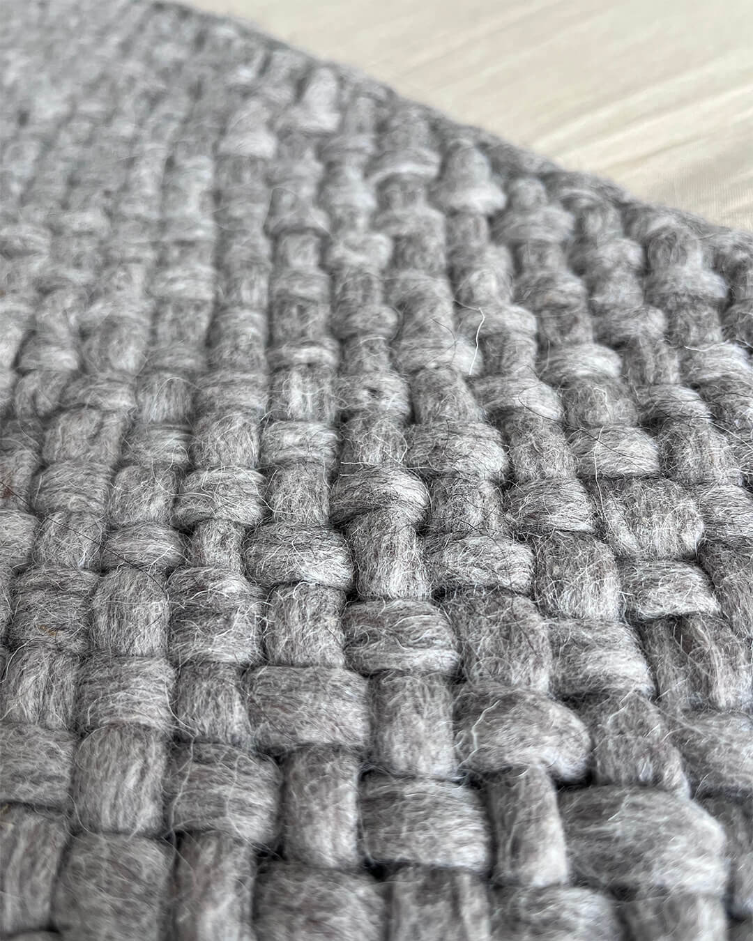 Close-up of the Gray wool throw’s woven texture and hand-dyed fiber.